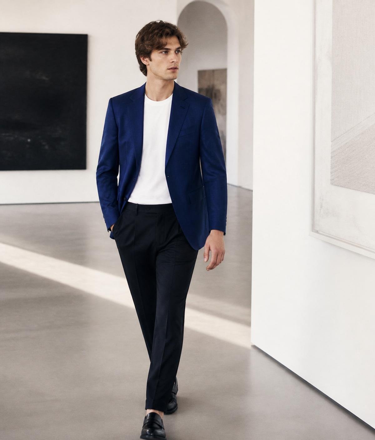 Man in royal blue tailored blazer walking through a gallery